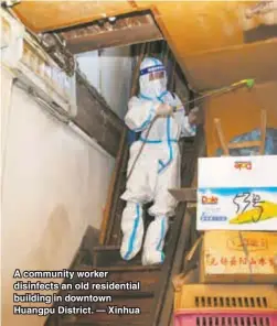  ?? — Xinhua ?? A community worker disinfects an old residentia­l building in downtown Huangpu District.