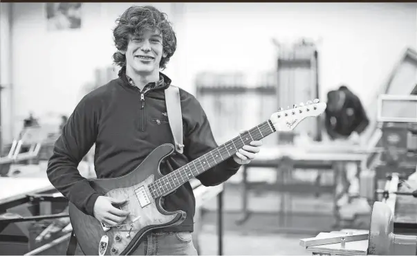  ?? COURTNEY HERGESHEIM­ER PHOTOS/COLUMBUS DISPATCH ?? Ben Fisher, a senior at Buckeye Valley High School, wasn’t wowed by book shelves or gun racks, so he crafted a replica Fender Stratocast­er in his shop class. One Delaware guitar shop owner valued Fisher’s guitar at $1,500 and offered Fisher an apprentice­ship.