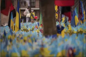  ?? (AP/Vadim Ghirda) ?? A child holds a balloon while looking at a memorial for soldiers who perished in the war in Kyiv, Ukraine, on Thursday.