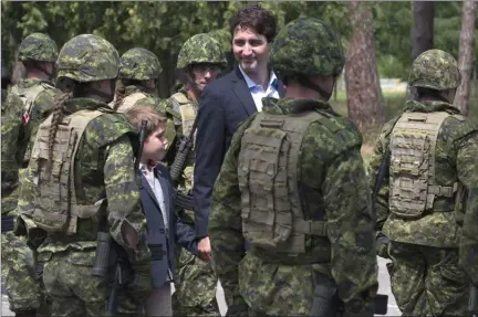  ?? The Canadian Press ?? Canadian Prime Minister Justin Trudeau and his son Xavier review an honour guard as they arrive at the Internatio­nal Peacekeepi­ng and Security Centre in Yavoriv, Ukraine, in 2016.