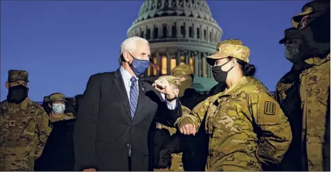  ?? Alex Brandon / The New York Times ?? Vice President Mike Pence elbow bumps with a member of the National Guard as he speaks to troops outside the Capitol in Washington on Thursday.