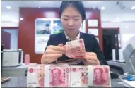  ?? CHINA NEWS SERVICE ?? A teller counts money at a bank in Taiyuan, capital of North China’s Shanxi province.