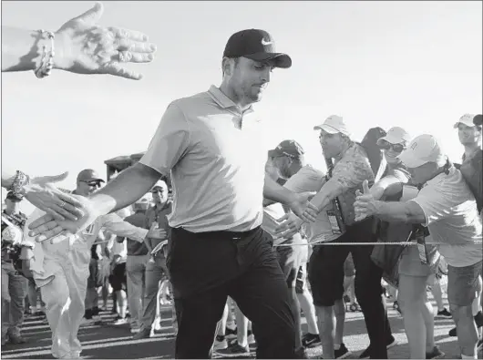  ?? MIKE EHRMANN/GETTY ?? Francesco Molinari walks off the 18th green after the third round of the Masters on Saturday. Molinari shot his second straight bogey-free round to take a two-stroke lead.