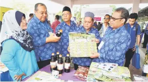  ?? — Gambar Bernama ?? TERTARIK: Abdul Fattah (kanan) melihat produk jualan anggota koperasi selepas merasmikan Majlis Persidanga­n ANGKASA Negeri Kedah di MRSM Merbok, semalam.