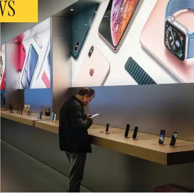  ?? BILLY H.C. KWOK / GETTY IMAGES ?? Customers browse inside an Apple store in Shenzhen, China. Apple lowered its revenue guidance on Wednesday, blaming China’s slowing economy and weaker than expected iphone sales.