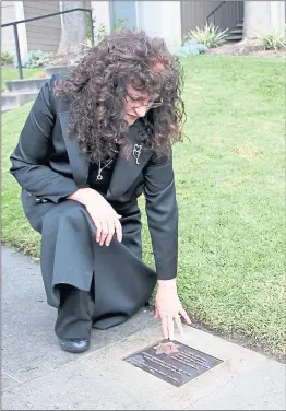  ?? PHOTO BY ROBERT SALONGA ?? Left: Katherine Decker, mother of slain Officer Michael Johnson, kneels next to a sidewalk plaque on Senter Road that was dedicated on Saturday, the third anniversar­y of when Johnson was shot and killed in the line of duty.