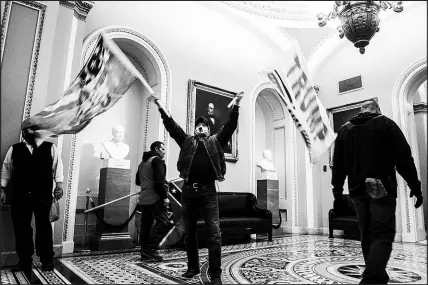  ?? ERIN SCHAFF / THE NEW YORK TIMES FILE (2021) ?? Rioters on Jan. 6, 2021, breach the U.S. Capitol building outside the Senate chamber. Former President Donald Trump this past weekend dangled pardons for Jan. 6 rioters and called for protests against those prosecutin­g the insurrecti­onists.