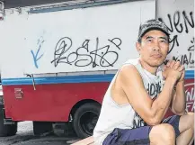  ?? TONY CALDWELL • POSTMEDIA NEWS ?? Jack Nguyen sits beside his Rideau Street chip truck, which was recently spray-painted with hate graffiti.