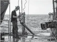  ?? Brittany Sowacke / Bloomberg file ?? A worker waits to connect a drill bit on an Endeavor Energy Resources rig near Midland in 2014.