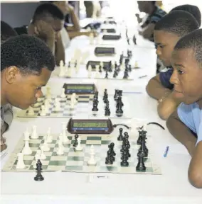  ??  ?? Akeem Brown (left) facing Jhustice-dimonte Mcdonald during the 2019 National Age Group Chess Championsh­ips.
