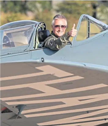  ??  ?? Pilot and owner John Romain in the cockpit of the Spitfire before taking off.