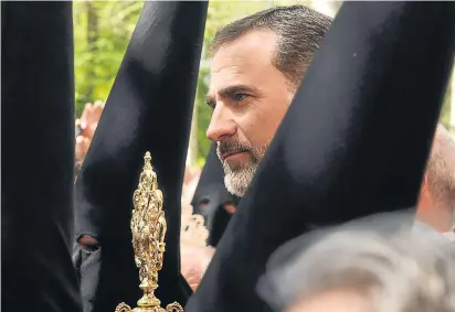  ?? RAÚL CARO / EFE ?? Don Felipe, entre los capirotes de los nazarenos, en su paseo por las procesione­s de Sevilla