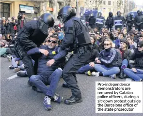  ??  ?? Pro-independen­ce demonstrat­ors are removed by Catalan police officers, during a sit-down protest outside the Barcelona office of the state prosecutor