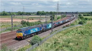  ?? IAN NIGHTINGAL­E ?? The failure of DRS Class 88 No. 88001 Revolution on a Dagenham-Garston train of new Ford vehicles saw No. 57002 Rail Express sent as the rescue loco, and the train is seen approachin­g Lichfield Trent Valley on June 17.