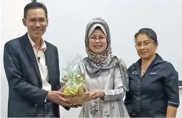 ??  ?? Fatimah (centre) receives a token of appreciati­on from Sarawak Welfare Department acting director Joni Nuruddin (left) while Dr Christie looks on.