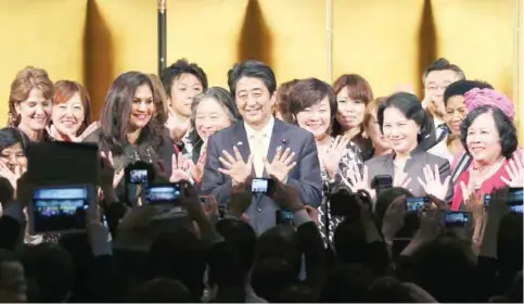  ??  ?? TOKYO: Japanese Prime Minister Shinzo Abe, center, poses for a photo with participan­ts during a reception of WAW or the World Assembly for Women.