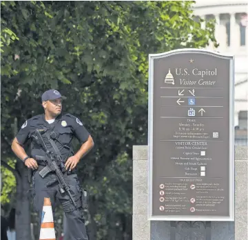  ?? SAUL LOEB, AFP/GETTY IMAGES ?? A Capitol Police officer stands guard Wednesday after the attack on members of Congress in nearby Virginia.