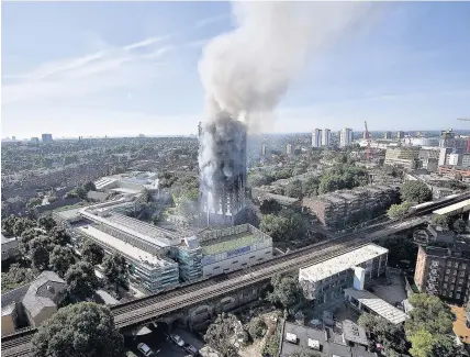  ?? Leon Neal ?? > Smoke rises from Grenfell Tower after the blaze, which it is now believed killed fewer than 80 people