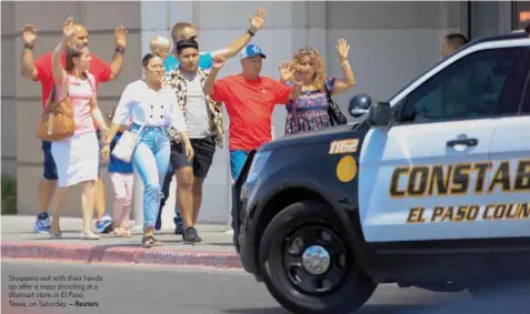  ?? — Reuters ?? Shoppers exit with their hands up after a mass shooting at a Walmart store in El Paso, Texas, on Saturday.
