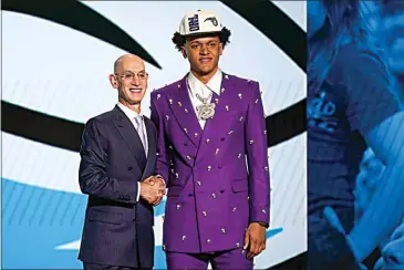  ?? PHOTOS BY JOHN MINCHILLO / AP ?? Paolo Banchero, right, poses for a photo with NBA Commission­er Adam Silver after being selected as the number one pick overall by the Orlando Magic in the NBA draft Thursday in New York.