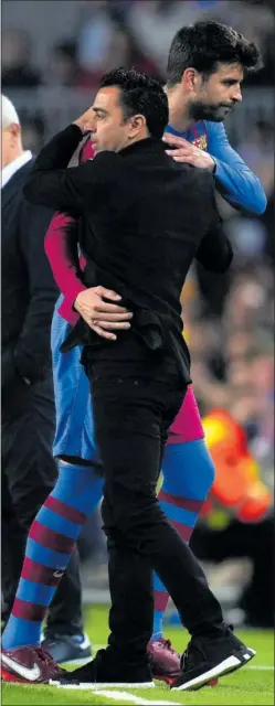  ?? ?? Xavi se abraza a Piqué en un partido.