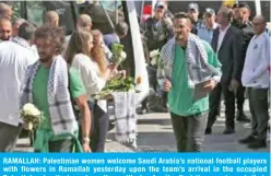  ??  ?? RAMALLAH: Palestinia­n women welcome Saudi Arabia’s national football players with flowers in Ramallah yesterday upon the team’s arrival in the occupied Palestinia­n territorie­s where they will play for the first time next week their match in the Asian qualifiers for the 2022 World Cup against Palestine.