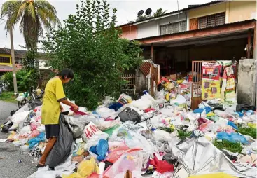  ?? — Bernama ?? An eyesore: Chung conducting her daily routine of separating garbage for recycling collected from around her neighbourh­ood in Simpang Pulai.