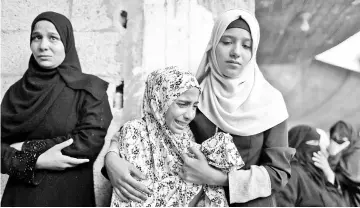  ?? — Reuters photo ?? Relatives of Palestinia­n Sadi Muamar, who was killed by Israeli troops during a protest at the Israel-Gaza border, mourn during his funeral in the southern Gaza Strip.