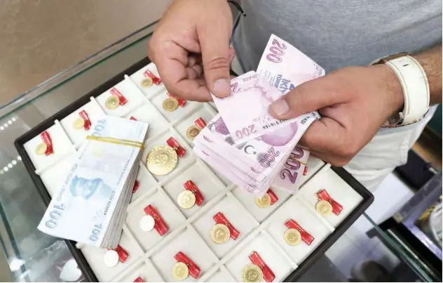  ?? Reuters ?? ↑
A gold dealer counts Turkish lira banknotes at his shop in Grand Bazaar in Istanbul, Turkey.