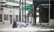  ??  ?? A vehicle drives on flooded Brickell Avenue in Miami on Sunday as Hurricane Irma passes.
