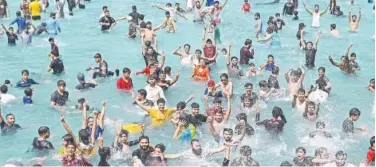  ?? Agence France-presse ?? ↑
People cool off at a swimming pool during a hot summer day in Lahore on Thursday.