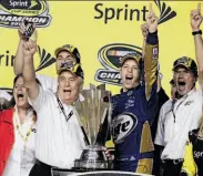  ?? Alan Diaz / Associated Press ?? Brad Keselowski (in blue) helped give owner Roger Penske (third from left) his first NASCAR title.