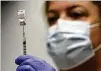  ?? ROBERT F. BUKATY/AP ?? Pharmacy tech Hollie Maloney loads a syringe with Pfizer’s COVID-19 vaccine (now called Comirnaty) at the Portland (Maine) Expo in March. The vaccine received full approval Monday.