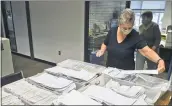  ?? BEN HASTY — MEDIANEWS GROUP ?? Donna Blatt, the Berks County chief registrar, sorts through the applicatio­ns the county elections office has received for mail- in ballots earlier this month.