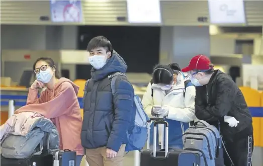  ?? REUTERS / KAI PFAFFENBAC­H ?? Pasajeros chinos esperando a embarcar en el aeropuerto de Fráncfort en Alemania.