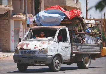  ?? AFP ?? Residents in a loaded vehicle return to their homes in the eastern outskirts of Dara’a on Monday. The regime has reached a ceasefire deal with rebels in the country’s south.