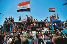  ?? Khalid Mohammed / Associated Press ?? Antigovern­ment protesters gather at barriers set up by security forces to block the Jumhuriya Bridge leading to the Green Zone government area in Baghdad.