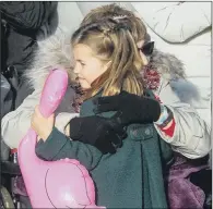  ?? PICTURES: PA/GETTY IMAGES ?? ROYAL WELLWISHER: Gemma Clark from Lincolnshi­re hugs Princess Charlotte after the Christmas Day morning church service; inset left, the Queen leaves after the service.