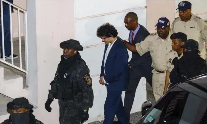  ?? Photograph: Austin Fernander/AP ?? FTX founder Sam Bankman-Fried, centre, is escorted out of court, following his arrest in Nassau, Bahamas, 13 December 2022.
