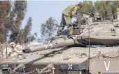  ?? Tsafrir Abayov / Associated Press ?? An Israeli soldier looks over a tank near the Israeli-Gaza border on Tuesday.