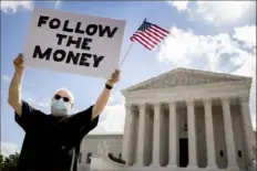  ?? Andrew Harnik/Associated Press ?? Bill Christeson holds up a sign on Thursday outside the Supreme Court in Washington.