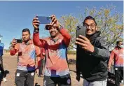  ??  ?? Members of the championsh­ip-winning Patel Brothers team — Mehul, Kunal, and Kushal Patel — take pictures of the city’s first cricket field on Sunday.