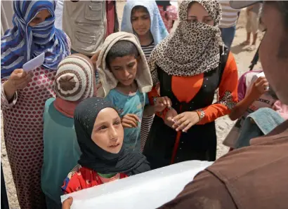  ?? —AFP ?? Displaced Iraqis wait to receive ice at the Jadaah camp on the outskirts of Al Qayyarah, south of Mosul, on Wednesday.