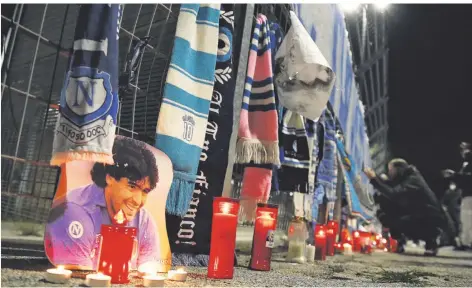  ?? FOTO: TARANTINO/DPA ?? In der ganzen Welt trauern Fußballfan­s wie hier vor dem San-Paolo-Stadion des SSC Neapel um Diego Maradona.