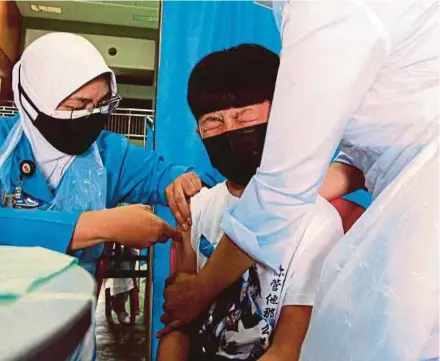  ?? BERNAMA PIC ?? A pupil, 12, grimacing while being vaccinated at SJK (C) Triang 2 in Bera, Pahang, recently.