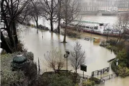  ?? — AFP ?? A playground on the banks of the Seine river is seen flooded in Paris on Monday. Paris remains on yellow alert, the third highest warning for flooding, according to the environmen­t ministry’s Vigicrues flood watch website. The walkways next to the...
