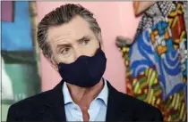  ?? JEFF CHIU — ASSOCIATED PRESS ?? Gov. Gavin Newsom wears a protective mask on his face while speaking to reporters in June 2020during the height of the pandemic. The governor recently talked about his policies during that time.