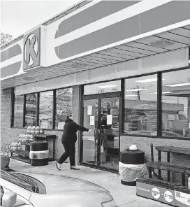  ?? [PHOTOS BY DAVID DISHMAN, THE OKLAHOMAN] ?? An individual walks back inside a closed Circle K at 1101 W Memorial Road after moving items outside. The store is closed, and several people were working inside to remove inventory from shelves.