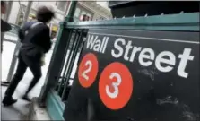  ?? RICHARD DREW — THE ASSOCIATED PRESS FILE ?? People pass a Wall Street subway stop in New York’s Financial District.