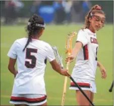  ?? PETE BANNAN — DIGITAL FIRST MEDIA ?? Archbishop Carroll’s Alex Cabahug-Almonte and Sam Swart (1) tap sticks after a Swart goal against Cardinal O’Hara in the first half of the Catholic League Championsh­ip Monday night.